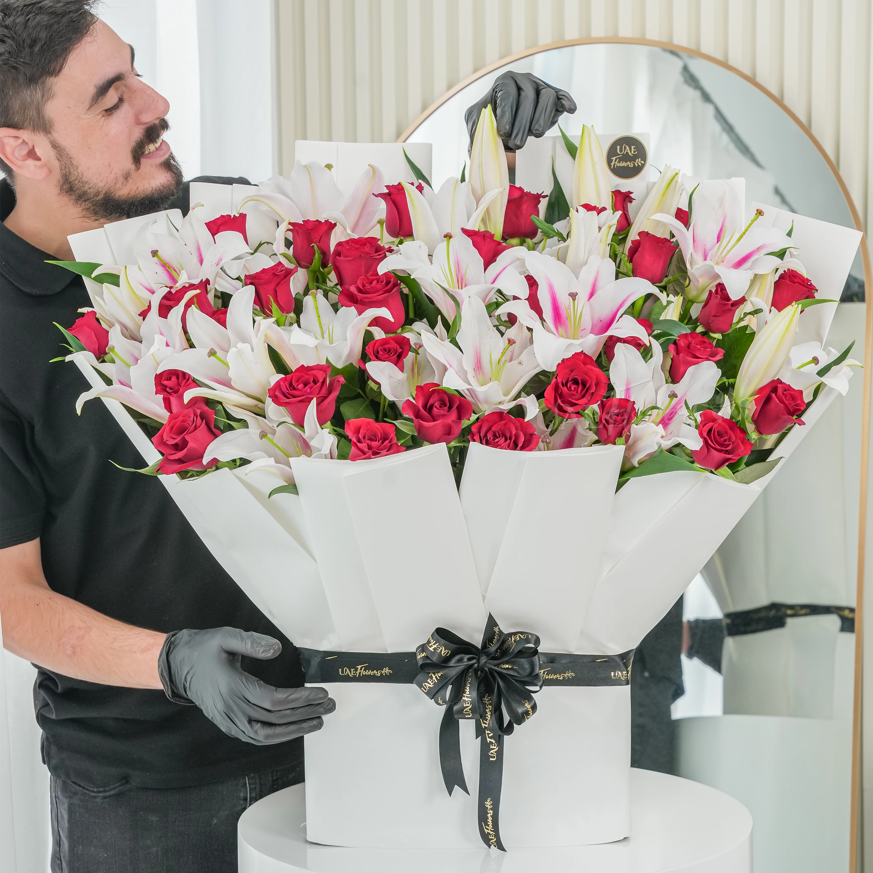 Bouquet of 10 pink lilies and 30 red roses with green fillers tied with ribbons.