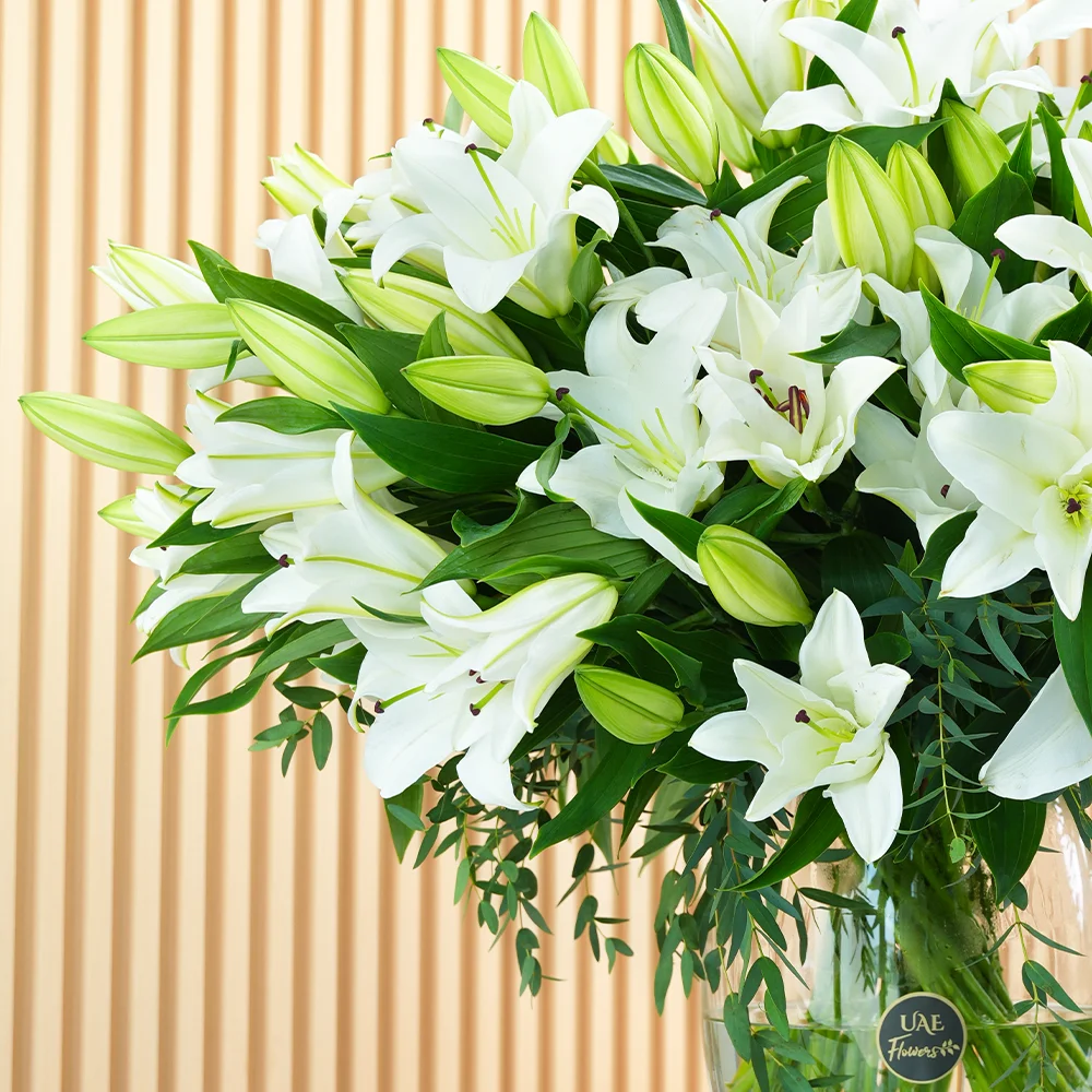 glass vase with 20 white lilies and green fillers