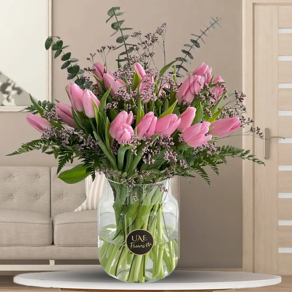 30 pink tulips with fillers in a glass vase