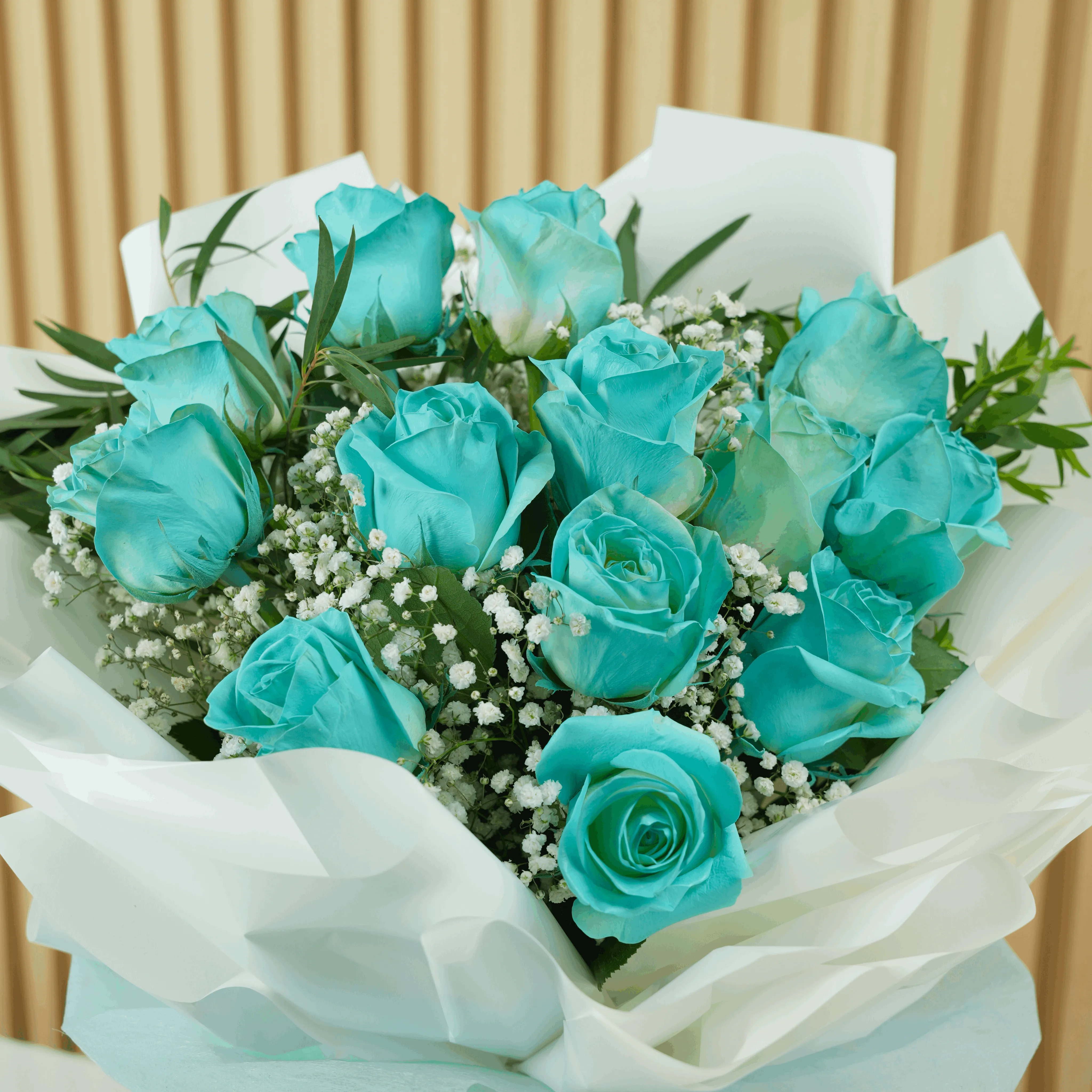 bouquet of 12 vivid blue roses wrapped with care and tied with ribbons