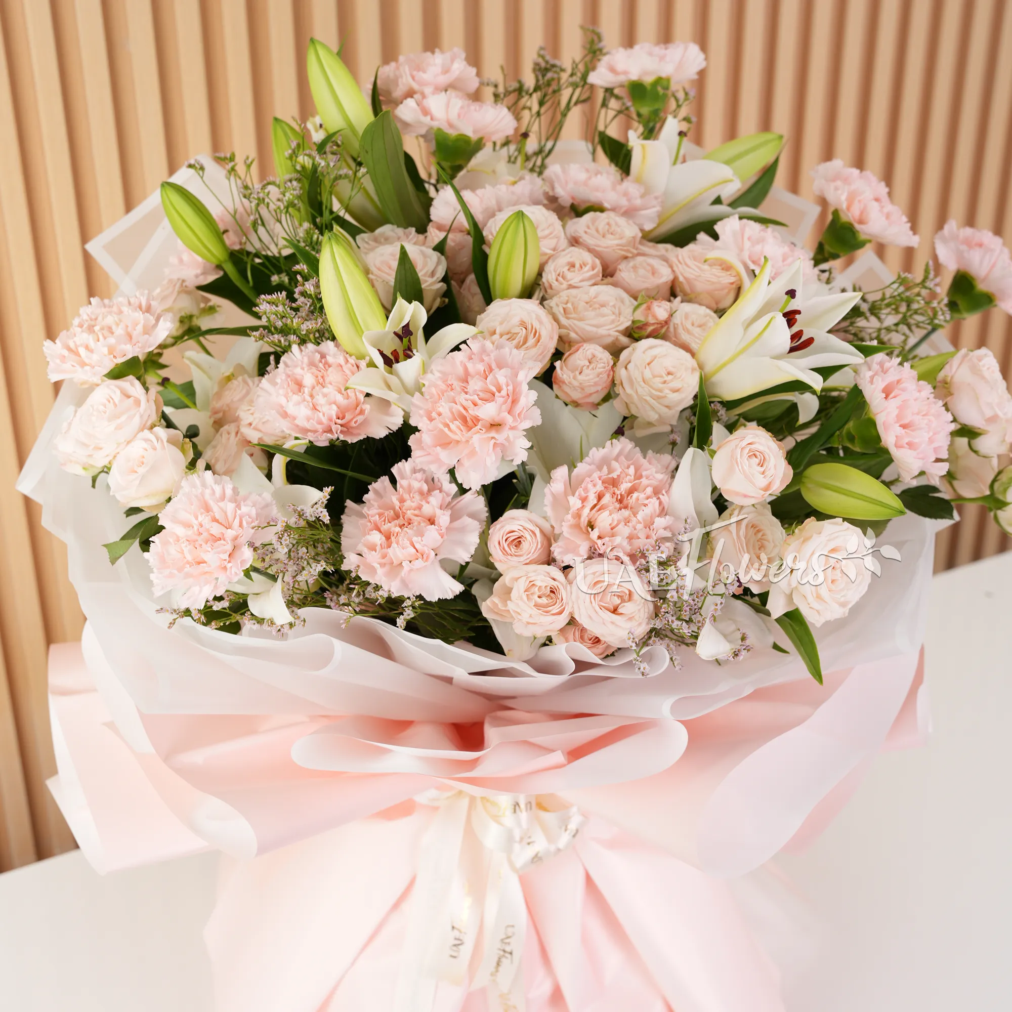 5 white lilies, 10 pink carnations, and 10 pink spray roses with green fillers,
