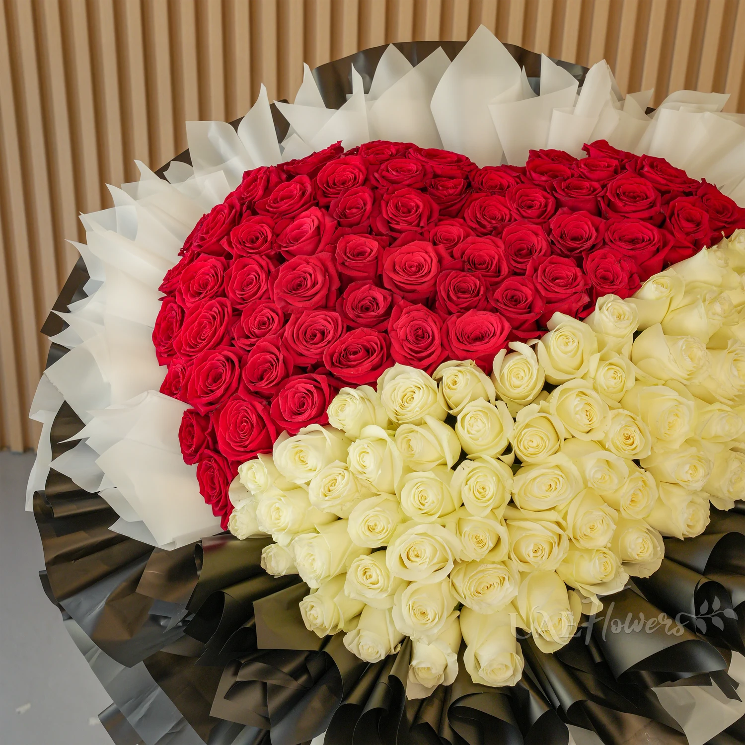 bouquet with 60 red and 60 white roses wrapped in black and white paper packing