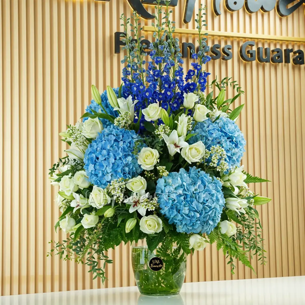 4 blue hydrangeas, 8 white lilies, 5 blue delphinium, and 20 white roses
