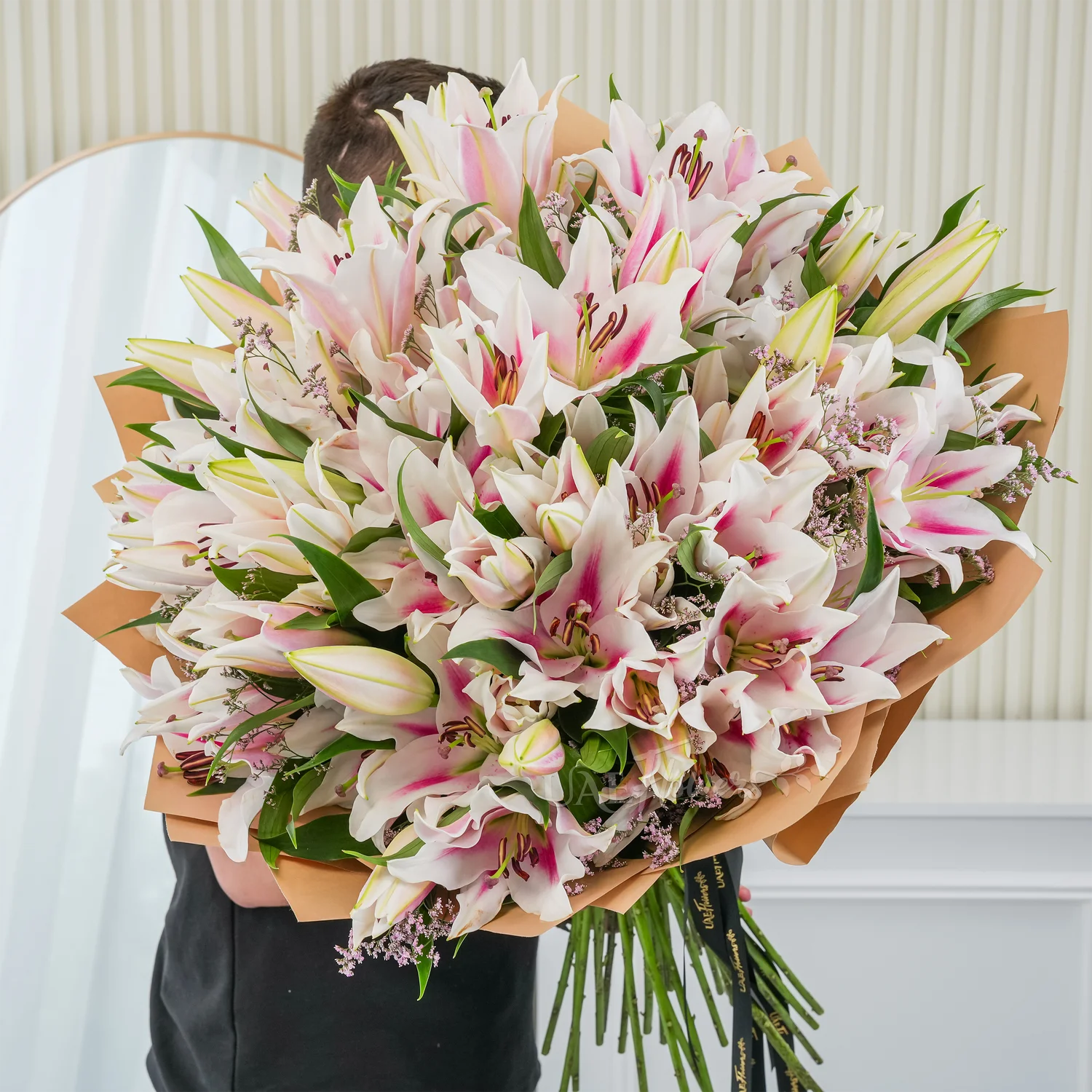 Bouquet of 30 pink lilies elegantly wrapped in premium paper and tied with ribbons – graceful and fragrant floral gift by UAE Flowers.