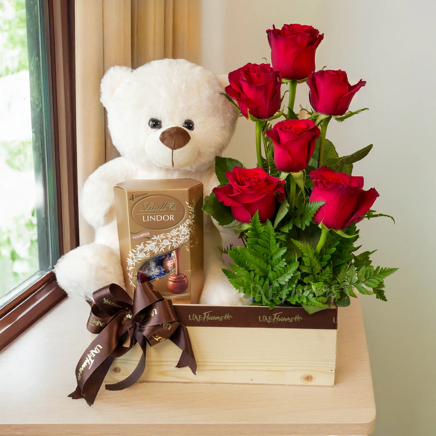 wooden tray with 6 red roses, green fillers, a small teddy bear, and 200g Lindt Lindor chocolates